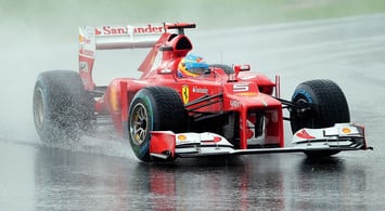Ferrari Алонсо на мокрой трассе автодрома Sepang
