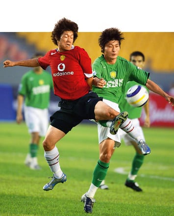 Полузащитник Manchester United Пак Чжи Сун (слева) против игрока Beijing Hyundai, 2005 г.