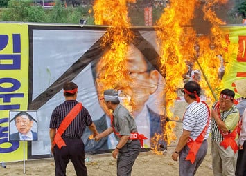 Демонстранты жгут портреты замешанного в коррупции Ким Юн Ена