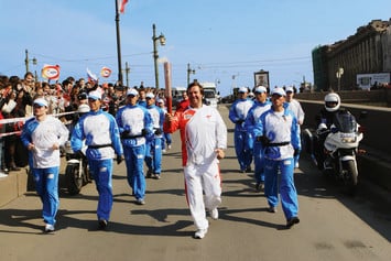 Владимир Сальников бежит свой этап эстафеты олимпийского огня в Санкт-Петербурге